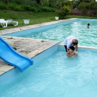 Bebe na piscina infantil com auxilio do monitor