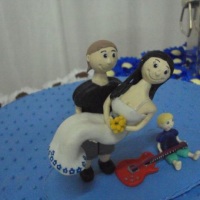 Noivinhos de biscuit estilo bonequinho personalizados com filho do casal e guitarra do noivo