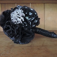 Buqu artesanal na cor preta, com flores de tecido e aplicao de broches.