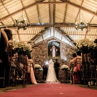 Os noivos no altar, com esse corredor decorado em margaridas.